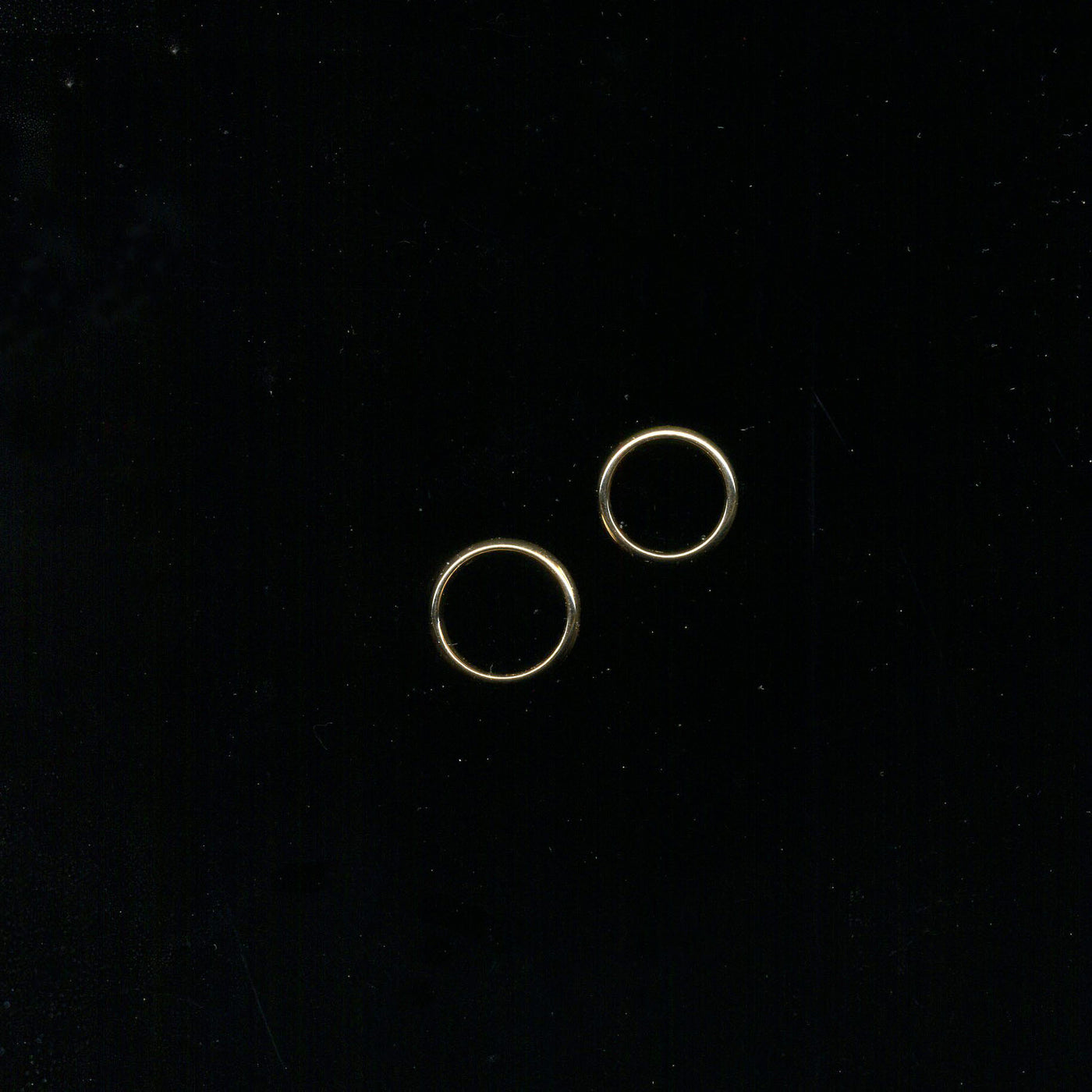 Two red-gold wedding bands against a dark background